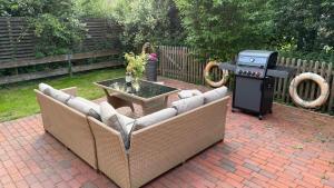 a bbq with a couch and a table and a grill at Hildas romantische Ferienwohnung in Gödenstorf
