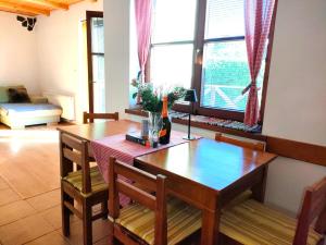 a dining room with a table and chairs and windows at Eternity Chalet Trnovec in Liptovský Trnovec
