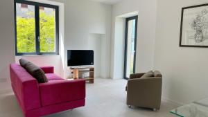 a living room with two chairs and a tv at Il Porticciolo in Lezzeno