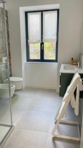a white bathroom with a sink and a window at Il Porticciolo in Lezzeno