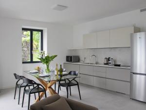 a kitchen with a table and chairs and a refrigerator at Il Porticciolo in Lezzeno