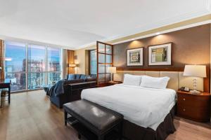 a hotel room with a bed and a couch at No Resort Fee Strip View Suites+ Free Valet + Pool in Las Vegas