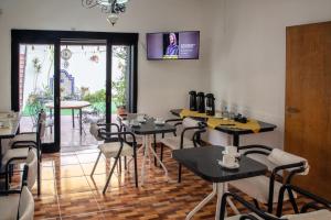 a restaurant with tables and chairs and a tv on the wall at Hostel Pituco - En el corazón de la ciudad in Mendoza