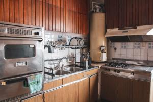a kitchen with a sink and a stove at Hostel Pituco - En el corazón de la ciudad in Mendoza