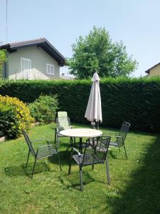 CentalloCasa Strada Facendo的草地上摆着一张桌子和几把椅子，还有一把遮阳伞