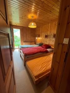 - une chambre avec 2 lits dans une cabane en bois dans l'établissement Appartement avec jardin au coeur de la nature, à Zinal