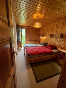 une chambre avec un lit dans une pièce en bois dans l'établissement Appartement avec jardin au coeur de la nature, à Zinal