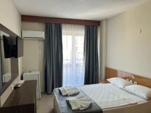 A bed or beds in a room at Rosella Hotel