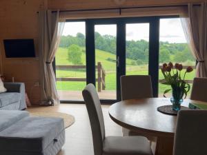 a living room with a table and chairs and a large window at Primrose in Chard