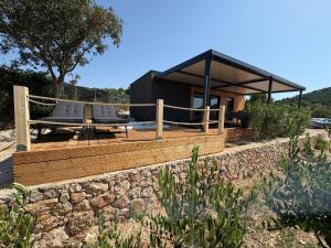 a house with two chairs and a table on a deck at Aurea Beach House in Tisno
