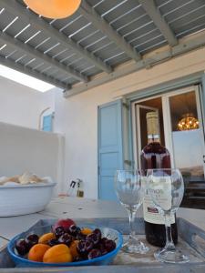 a bottle of wine and two glasses on a table at Phaedra Villa Kythnos in Kithnos
