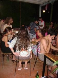 un gruppo di persone seduti su sedie a una festa di Hostel Ibirapita a La Paloma