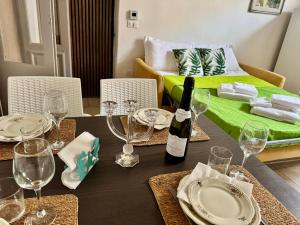 a dining table with a bottle of wine and glasses at Dimora Marina in Monopoli