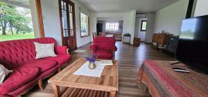 a living room with a red couch and a table at Casa de campo Don Juan in Duggan