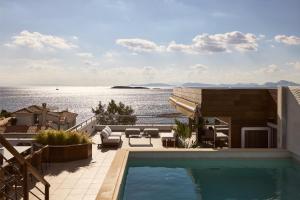 アテネにあるCasa Volare, Penthouse Retreat - Athenian Rivieraの水辺の景色を望む建物の最上階にスイミングプールがあります。
