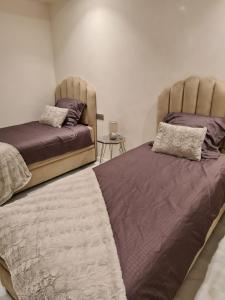 two beds sitting next to each other in a bedroom at Appartement sur la corniche 2 chambres in Tangier +24 photos