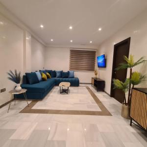 un salon avec un canapé bleu et une télévision dans l'établissement Appartement sur la corniche 2 chambres, à Tanger 24 autres photos