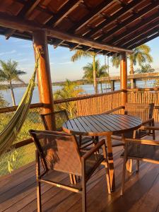 a porch with a hammock and a table and chairs at Casa no Condomínio Naútico Porto da Pedra em Ijaci in Macaia