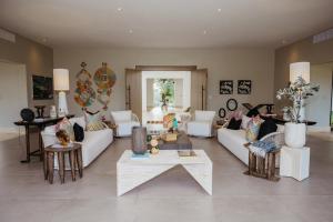 Una sala de estar con sofás y mesas blancos. en Casa Roble, en La Romana
