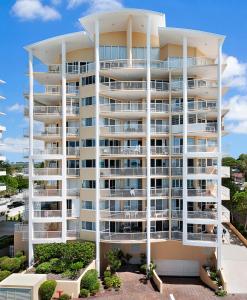 a large white apartment building with balconies at Riviere on Golden Beach in Caloundra