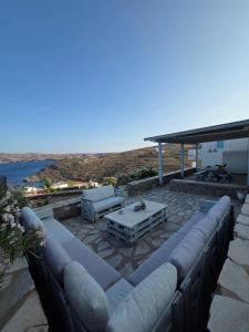 a patio with a couch and a table at Phaedra Villa Kythnos in Kithnos