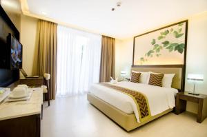 a hotel room with a large bed and a desk at Boracay Haven Suites in Boracay