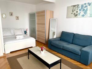 una sala de estar con un sofá y una cama en Appartement meublé proche de la Gare de Lausanne 12, en Lausana