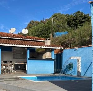 ein Haus mit einer blauen Wand mit einem Brunnen in der Unterkunft sitio sonho verde in Serra Negra