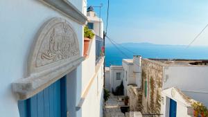a view of a narrow alley with white buildings at Traditional Stone House Istérnia in Istérnia