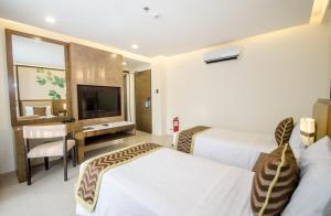 a hotel room with two beds and a television at Boracay Haven Suites in Boracay