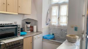 a kitchen with a counter with a stove and a window at Traditional Stone House Istérnia in Istérnia