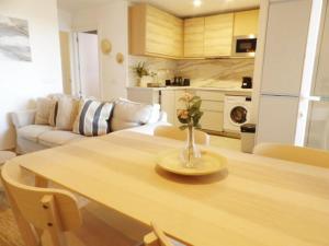 a living room with a table with a vase of flowers on it at Can Isabel, apartamento con piscina, restaurante y zona de juegos in Cala en Porter