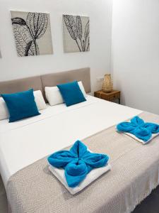 Un dormitorio con una cama con almohadas azules. en Can Isabel, apartamento con piscina, restaurante y zona de juegos, en Cala'n Porter