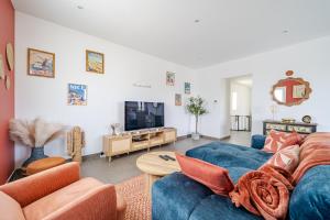ニースにあるMaison avec jardin Vue dégagéeの青いソファとテレビのあるリビングルーム
