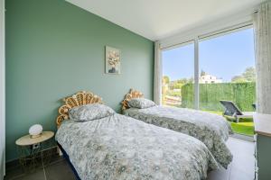 ニースにあるMaison avec jardin Vue dégagéeの窓のある部屋にベッドが2つある