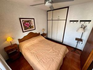 a bedroom with a bed and two tables and two lamps at Departamento Punta del Este in Punta del Este +3 photos