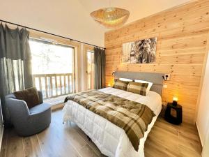 a bedroom with a bed and a chair and a chandelier at Chalet N°5 - CHALET PRESTIGE 9 P. PROCHE PISTES-Tout inclus MAE-4253 in Vars +23 photos