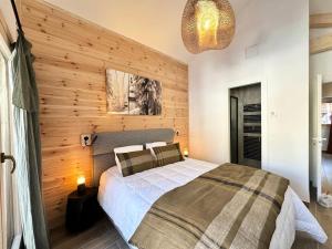 a bedroom with a bed and a wooden wall at Chalet N°5 - CHALET PRESTIGE 9 P. PROCHE PISTES-Tout inclus MAE-4253 in Vars