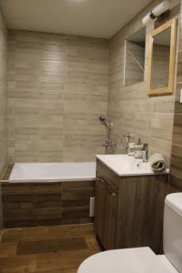a bathroom with a tub and a toilet and a sink at Squirrel cottage in Dolná Lehota +61 photos