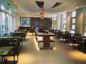 a dining room with tables and chairs and windows at Boracay Haven Suites in Boracay