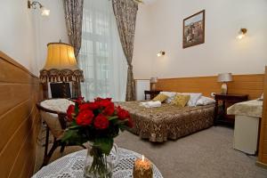 Un dormitorio con una cama y una mesa con un jarrón de flores en Pokoje Gościnne Unikat - Self check in, en Cracovia