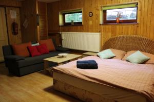 a bedroom with a large bed and a couch at Squirrel cottage in Dolná Lehota