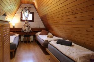 une chambre avec deux lits dans une cabane en bois dans l'établissement Squirrel cottage, à Dolná Lehota