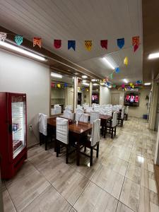 ein Esszimmer mit Tischen, Stühlen und Flaggen in der Unterkunft O melhor custo benefício da cidade - Hotel Ceará in Pinheiro