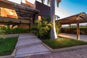 Un edificio con una palmera y escaleras delante. en 1007 -- Casa Buena Vida, en Santa Cruz Huatulco