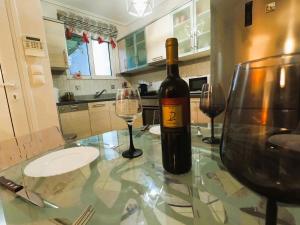 a bottle of wine sitting on a table with two glasses at Stylish 2BR Semi-Basement- Cozy & Family-Friendly Retreat in Loutraki +24 photos