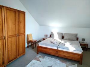 a bedroom with a bed and a wooden cabinet at Eternity Chalet Trnovec in Liptovský Trnovec +34 photos