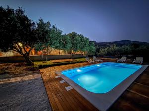 a swimming pool on a wooden deck with chairs at Villa Olea Lux Bol in Bol