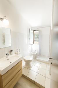 a white bathroom with a toilet and a sink at Sabbiamare Relax e Mare in Torre Dei Corsari