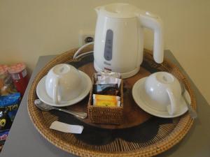 a table with affeepot and two cups and a blender at Scallywags Mango in Gili Islands